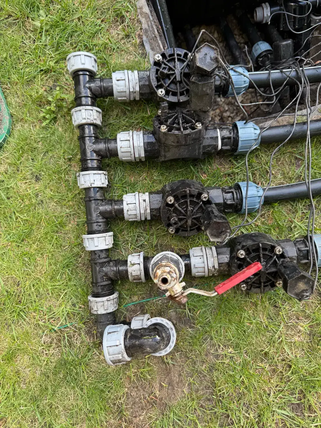 Kolektor PE z elektrozaworami i zaworem kulowym wyjęty ze skrzynki zaworowej podczas serwisu nawadniania
