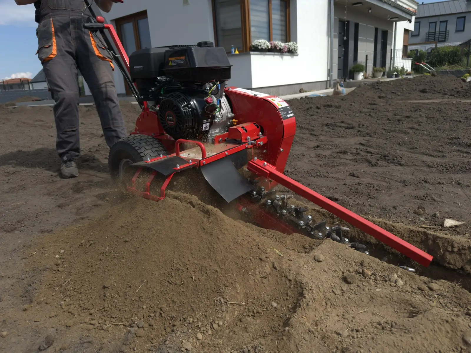 Łańcuch koparki trencher wybiera ziemię, równe dno rowka pod rurę PE