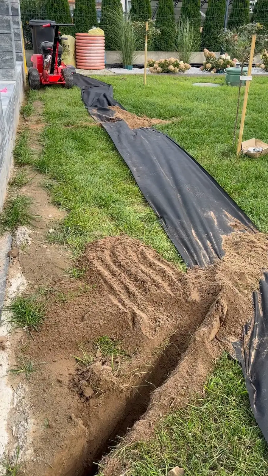 Koparka łańcuchowa na końcu wąskiego wykopu pod rury nawadniania, urobek na folii, okolice Stargardu